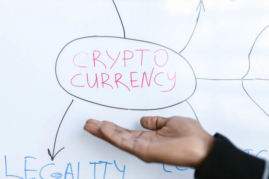 A hand is holding a smartphone showing a BTC-USD chart among digital trading screens, emphasizing crypto finance.
